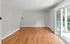 Spacious living room with hardwood floors and large sliding glass doors leading to a balcony with a scenic view.