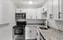 Chic kitchen with white cabinetry, stainless steel appliances, and granite countertops.