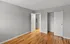 Bright, empty bedroom with hardwood flooring and a sliding door closet.