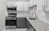 Contemporary kitchen with granite countertops, white cabinets, and stainless steel appliances.