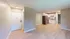 Bright open kitchen with white cabinets, modern appliances, and expansive hardwood flooring.