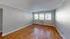 Spacious living room with hardwood floors and large windows allowing natural light.