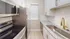 Modern kitchen featuring sleek stainless steel appliances, granite countertops, and white cabinetry.