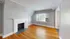 Inviting living room featuring a classic white fireplace and a large window with natural light.
