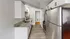 Contemporary kitchen with granite countertops, stainless steel appliances, and white cabinetry.