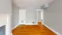 Bright and cozy living room with hardwood floors, elegant fireplace, and open doorway.