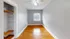 Bright room with hardwood floor, white walls, closet, and window view.