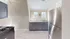 Contemporary kitchen with stainless steel appliances, sleek grey cabinetry, and marble tile flooring.