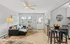 Inviting living room with a modern black sofa, stylish decor, and an open layout leading to a sleek kitchen.