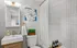 Modern bathroom with stylish fixtures, ceramic tiles, and decorative artwork.
