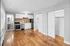 Charming open-plan kitchen and living area with modern appliances, wooden flooring, and ample natural light.