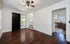 Bright living space with rich hardwood floors and an inviting ceiling fan, leading into a modern kitchen with sleek cabinetry.
