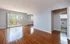 Bright and airy living room with polished hardwood floors, large sliding glass doors, and an inviting view of lush greenery.