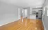 Modern apartment featuring an open floor plan with sleek hardwood floors, a stylish kitchen with stainless steel appliances, and abundant natural light through large windows.
