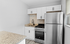 Modern kitchen with sleek stainless steel appliances, granite countertops, and elegant white cabinetry.