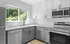 Cincinnati two bedroom apartment, alcove of turpin hills, Modern kitchen with sleek stainless steel appliances, elegant white and gray cabinetry, and large windows offering lush green views.