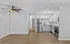 Modern open-concept kitchen with sleek stainless steel appliances, elegant white cabinetry, and stylish wood flooring.
