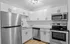 Modern kitchen featuring stainless steel appliances, sleek countertops, and elegant white cabinetry.