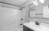 Modern bathroom with elegant marble shower walls, sleek fixtures, and a large mirrored vanity, alcove of turpin hills apartments