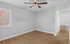 Bright empty room with elegant wood flooring, modern ceiling fan, and natural light through large window, Alcove of Turpin Hills Apartments