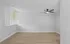 Bright, modern room with light wood flooring, fresh white walls, and a ceiling fan, ready for personal touches.