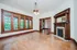 Charming living room with large wooden windows, elegant chandelier, and classic fireplace.