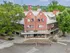 Charming brick building nestled in lush greenery, showcasing classic architecture and a serene urban setting.