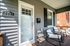 Inviting front porch with cozy seating, modern decor, and a charming doorstep, perfect for relaxing in the sun.