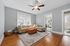 Bright living room featuring a cozy sectional sofa, stylish ceiling fan, and large windows for natural light.