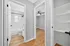 Inviting apartment hallway featuring elegant hardwood floors, a modern bathroom with white subway tiles, and a cozy room with a ceiling fan.