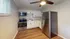 Modern kitchen featuring stainless steel appliances, sleek white cabinetry, and elegant wood flooring.