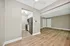 Modern apartment interior with open-concept living space featuring hardwood floors, sleek kitchen, and abundant natural light.
