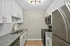 Elegant kitchen with granite countertops, white cabinetry, stainless steel appliances, and modern lighting.