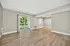 Bright and spacious living area with elegant wood flooring and large sliding glass door to a private balcony with scenic views.