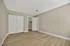 Charming, spacious bedroom with light wood flooring, neutral walls, and ample closet space for a modern touch.