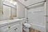 Modern bathroom with elegant gold fixtures, sleek white vanity, and a tiled bathtub creating a luxurious feel.