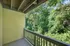 Charming apartment balcony with serene views of lush green trees, perfect for relaxation or enjoying nature.