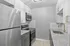 Sleek modern kitchen with granite countertops, elegant white cabinets, and stainless steel appliances.