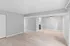Spacious open floor plan with light wood flooring, modern gray walls, and a cozy ceiling fan in a bright living area.