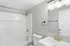 Modern bathroom with elegant gold fixtures, a sleek white vanity, and a spacious bathtub.
