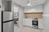 Modern kitchen with sleek stainless steel appliances, bright cabinetry, and open layout leading to a stylish bathroom.