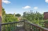 Charming balcony view overlooking lush greenery and urban skyline, perfect for relaxation and enjoying nature.