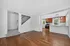Bright open-concept kitchen and living area with modern lighting, stainless steel appliances, and elegant hardwood floors.