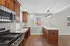 Bright contemporary kitchen with elegant granite countertops, rich wooden cabinets, and sleek stainless steel appliances.