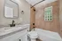 Modern bathroom with elegant granite countertop, sleek black fixtures, and stylish tile wall detail.