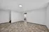 Bright and spacious room with modern flooring, leading to a convenient utility area with laundry facilities.