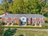 Charming brick apartment complex nestled among lush greenery, featuring classic architecture and well-maintained landscaping for a serene living environment.