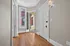 Inviting apartment entryway featuring hardwood floors, elegant glass door, and ample natural light.