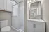 Elegant bathroom with sleek modern fixtures, glass-enclosed shower, and a spacious vanity under soft lighting.