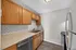 Modern kitchen with sleek stainless steel appliances, elegant wood cabinetry, and chic white subway tile backsplash.